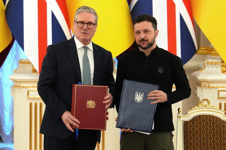 O primeiro-ministro britânico, Keir Starmer, e o presidente ucraniano, Volodymyr Zelensky, posam para fotos após realizar uma cerimônia de assinatura para comemorar uma parceria de 100 anos entre os países no Palácio Mariinsky, em Kyiv, Ucrânia [Carl Court/Pool/Reuters].
