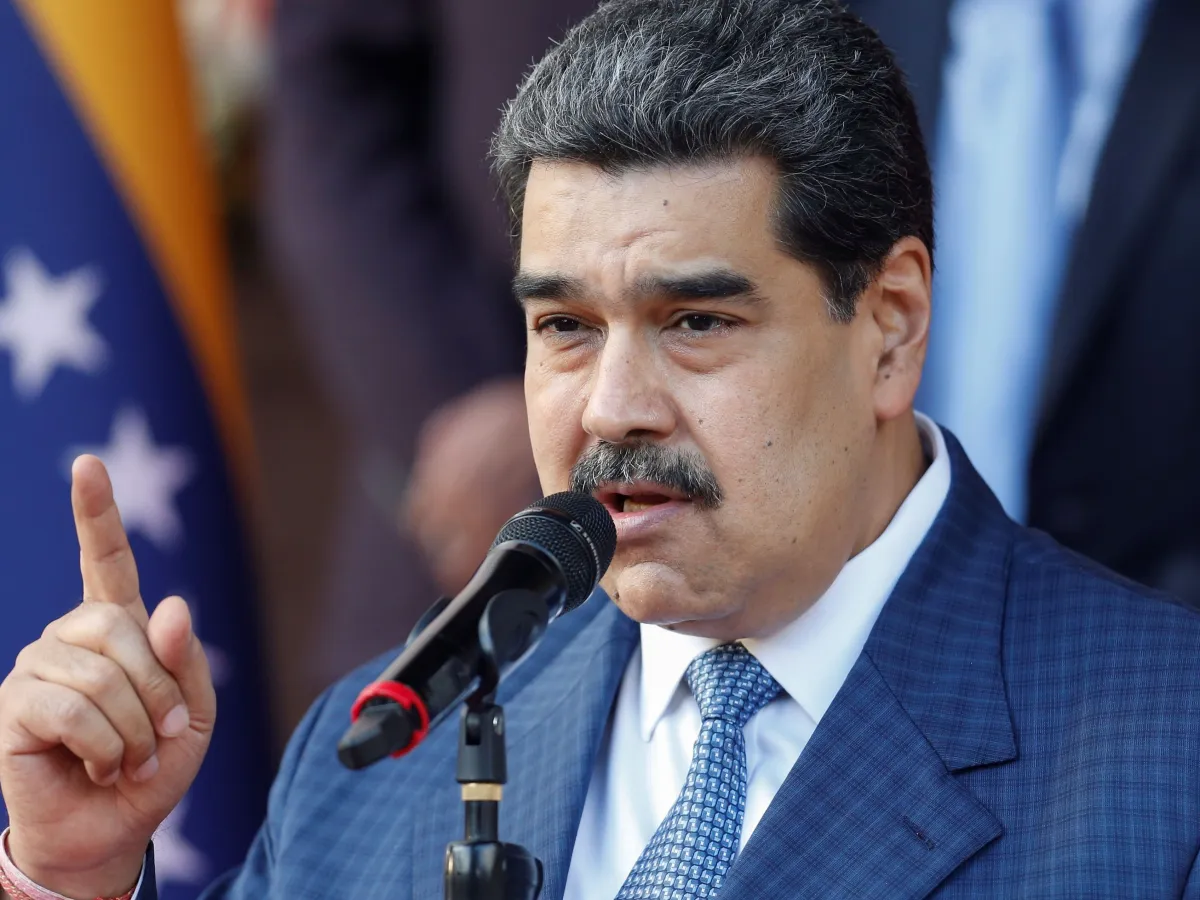 Nicolás Maduro discursando em evento de posse presidencial, com bandeiras da Venezuela ao fundo.