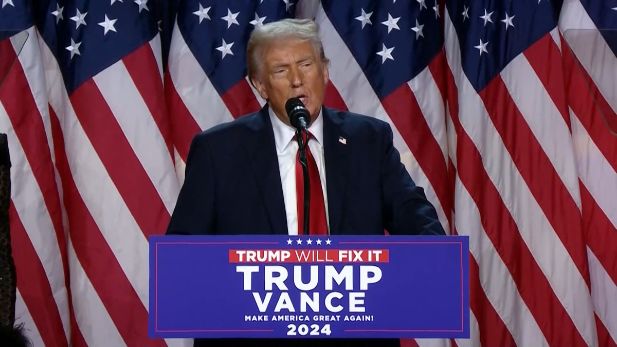 Donald Trump discursando, com um fundo que sugere o contexto das eleições, enquanto manifesta interesse na compra da Groenlândia e menciona ações militares ou econômicas.
