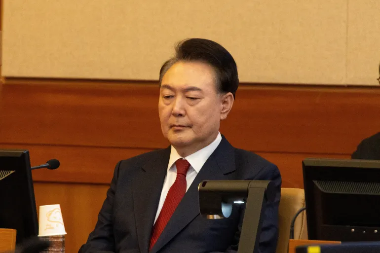 O presidente da Coreia do Sul, Yoon Suk-yeol, participa de seu julgamento de impeachment devido à breve imposição da lei marcial, no Tribunal Constitucional em Seul, em 13 de fevereiro de 2025 [Jeon Heon-Kyun/Pool via Reuters]. Fonte: Al Jazeera