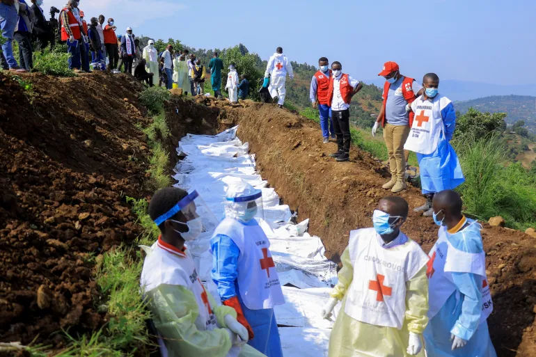 Membros da Cruz Vermelha enterram em uma vala comum os sacos mortuários contendo os restos mortais das vítimas mortas em Bukavu, leste da RDC [Victoire Mukenge/Reuters]. Fonte: Al Jazeera