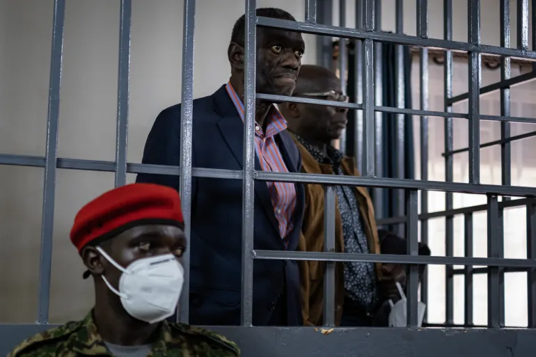 O veterano líder da oposição de Uganda, Kizza Besigye, está no banco dos réus no tribunal de Makindye, em Kampala, em 20 de novembro de 2024 [Badru Katumba/AFP]. Fonte: Al Jazeera