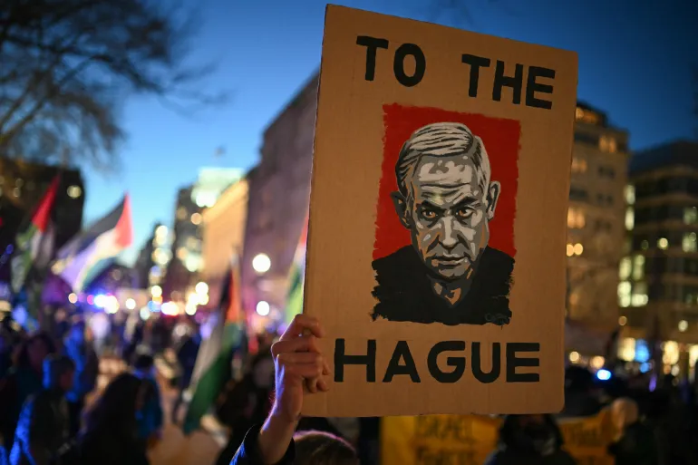 Manifestante com cartaz de Netanyahu em protesto próximo à Casa Branca, em apoio aos palestinos, 4 de fevereiro - Foto: Mandel Ngan/AFP.