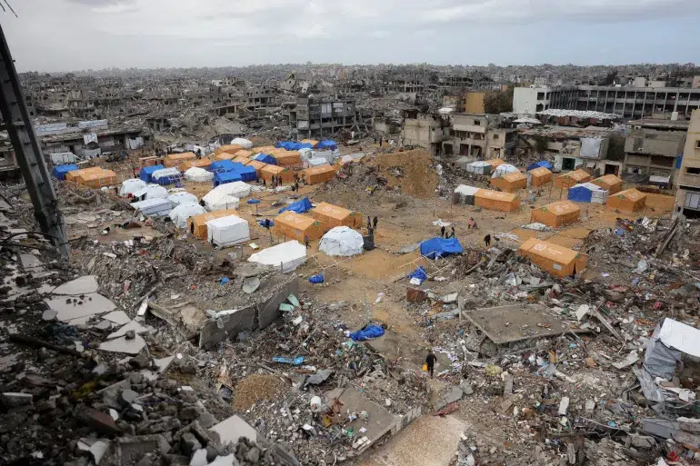 Palestinos buscam abrigo em tendas montadas entre edifícios severamente danificados em Jabalia, no norte da Faixa de Gaza [AFP]Foto: AL Jazeera