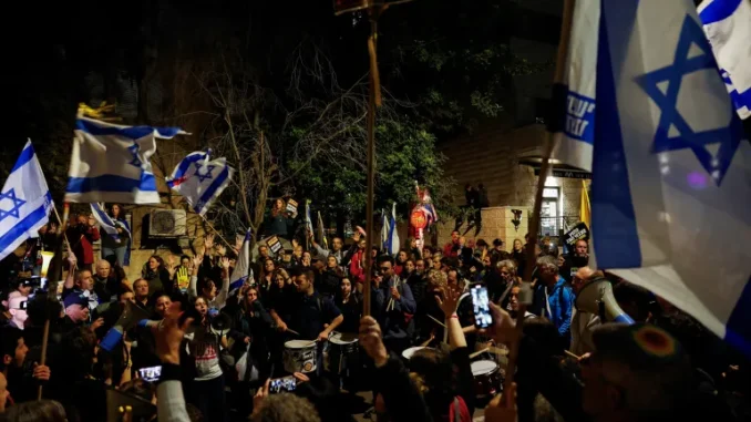 Manifestantes participam de um protesto contra o governo israelense devido aos seus planos de demitir a Procuradora-Geral Gali Baharav-Miara e o chefe do Shin Bet, Ronen Bar, próximo à residência do primeiro-ministro Benjamin Netanyahu, em Jerusalém Ocidental. [Ammar Awad/Reuters] Fonte: Al Jazeera