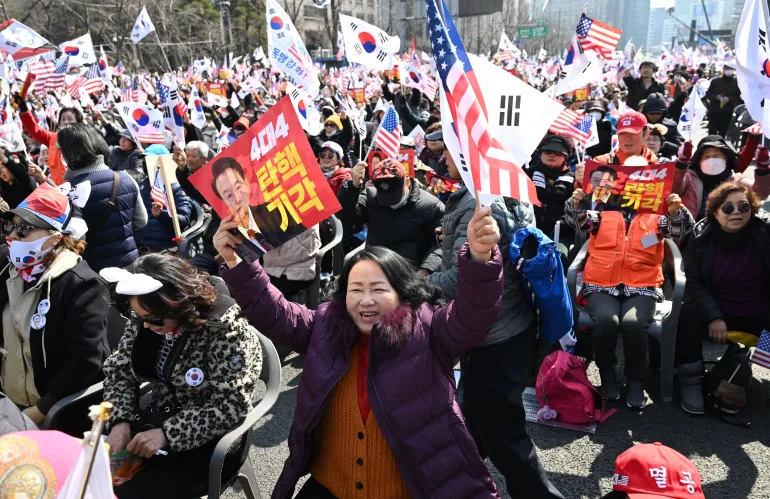 Apoiadores do presidente impugnado Yoon Suk-yeol agitam bandeiras da Coreia do Sul e dos EUA durante um comício no centro de Seul em 8 de março de 2025 [Jung Yeon-je/AFP].
Fonte: Al Jazeera

