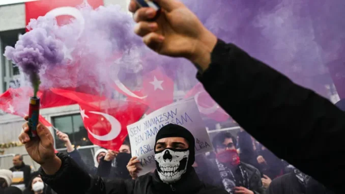 Protestantes seguram sinalizadores de fumaça roxa durante um comício em apoio ao prefeito de Istambul preso, na prefeitura de Istambul, em 24 de março de 2025 [Ozan Kose/AFP].