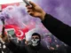 Protestantes seguram sinalizadores de fumaça roxa durante um comício em apoio ao prefeito de Istambul preso, na prefeitura de Istambul, em 24 de março de 2025 [Ozan Kose/AFP].