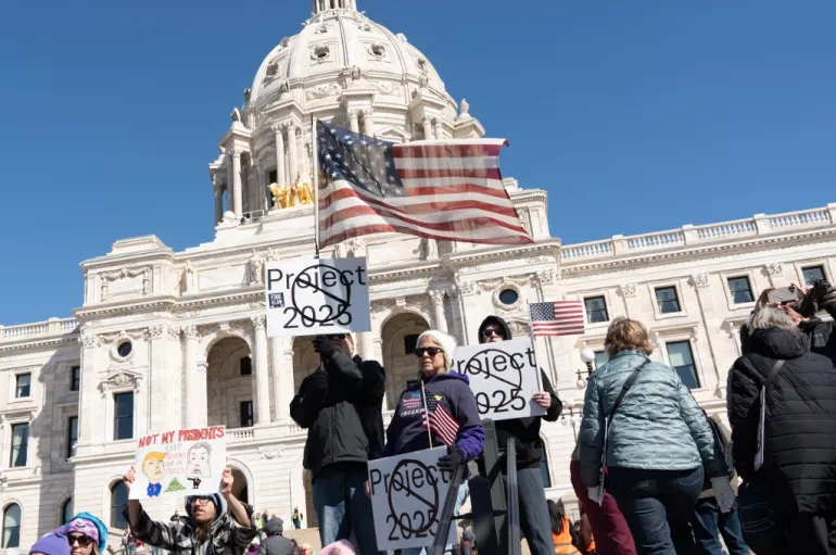 Manifestantes reúnem-se em frente ao Capitólio do Estado de Minnesota durante o protesto nacional Mãos Fora! contra o presidente dos EUA, Donald Trump, e seu conselheiro, o CEO da Tesla, Elon Musk, em St. Paul, Minnesota, em 5 de abril de 2025. Foto: Tim Evans/AFP Fonte: Al Jazeera