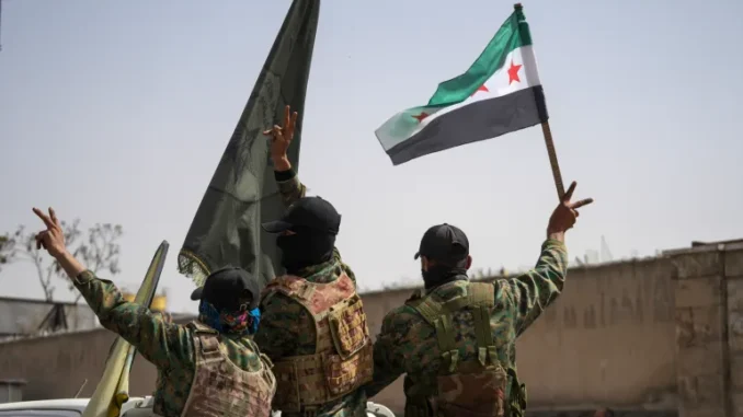 12957621-1745855906 Membros das Forças Democráticas Sírias (SDF) fazem o sinal de vitória ao deixar a cidade de Aleppo, Síria, em 9 de abril de 2025.