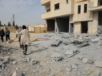 Pessoas caminham entre os destroços de uma área atingida por um ataque aéreo israelense em Hawsh Tal Safiyeh, perto de Baalbek, no Vale do Bekaa, Líbano, em 8 de abril de 2025.