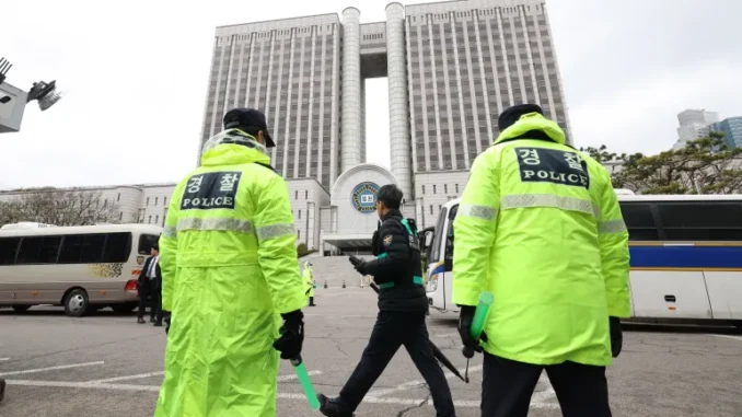 AFP__20250414__42982NP__v1__HighRes__SkoreaPoliticsCourtYoon-1744612843 Policiais de guarda na entrada do Tribunal Distrital Central de Seul aguardando a chegada do ex-presidente da Coreia do Sul, Yoon Suk-yeol.