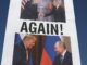 Cartaz com imagens de Donald Trump e Vladimir Putin apertando as mãos, com a palavra "AGAIN!" em destaque, durante protesto em frente a prédio histórico.