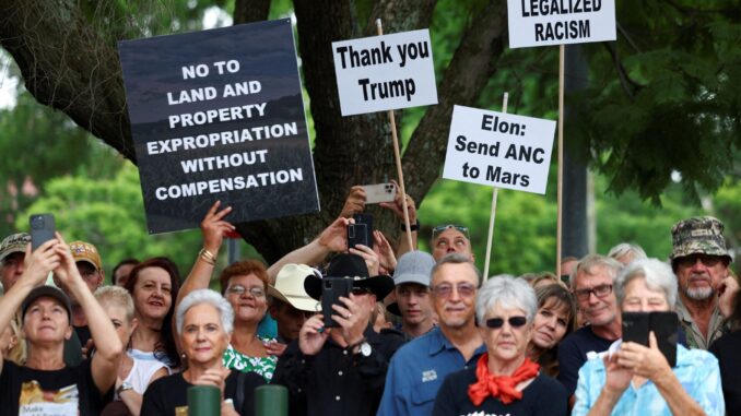 T3FHTE5H4FNKZJR2G7GMAH2YEE Manifestantes seguram cartazes em apoio à postura do presidente dos EUA, Donald Trump, contra leis racistas, expropriação de terras e ataques a fazendas, em frente à Embaixada dos EUA em Pretória, África do Sul, em 15 de fevereiro de 2025.