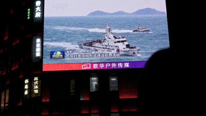 Um navio da Guarda Costeira da China é visto em uma tela gigante exibindo reportagens sobre as patrulhas de fiscalização da guarda costeira nas águas ao redor de Taiwan, do lado de fora de um shopping center em Pequim, China, em 1º de abril de 2025. REUTERS/Florence Lo