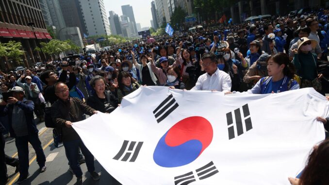 DDBFXTJWF5NQJPAV7DLW7YRYMA Apoiadores de Lee Jae-myung, candidato presidencial pelo Partido Democrático da Coreia do Sul, comemoram após comício em Seul, 12 de maio de 2025.