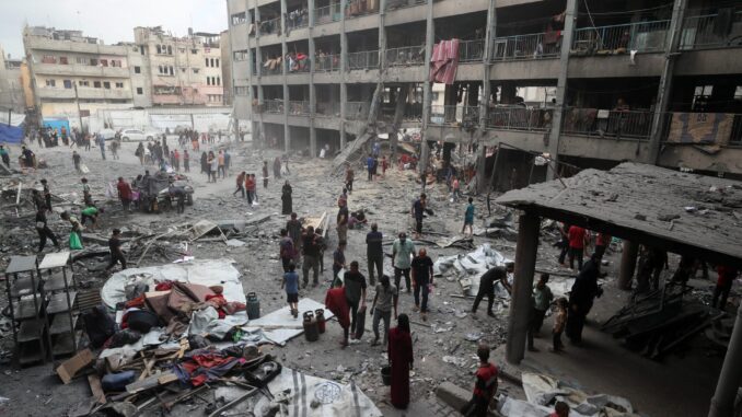 Palestinos inspecionam destruição em escola da ONU atingida por ataque aéreo israelense em Gaza.