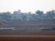 Caminhões carregados com ajuda humanitária cruzam a fronteira entre Israel e Gaza em direção ao enclave, vistos do lado israelense.