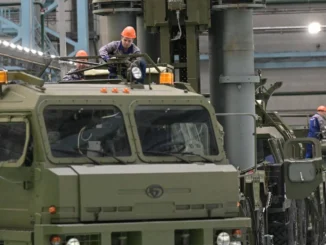 Operários russos trabalham na montagem de veículos militares em fábrica de defesa.