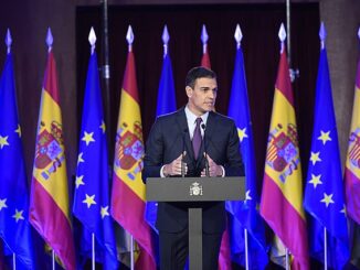 Pedro Sánchez discursando em conferência com bandeiras da Espanha e da União Europeia ao fundo.