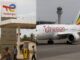 Posto de combustível da TotalEnergies em Moçambique e avião da Ethiopian Airlines no aeroporto com torre de controle ao fundo.