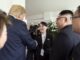 Kim Yo Jong sorrindo e cumprimentando Donald Trump durante reunião, com Kim Jong-un ao lado.