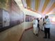 Primeiro-Ministro Narendra Modi visitando a exposição “Filosofia Saiva e as Artes do Templo dos Cholas” com um grupo de pessoas, em um ambiente iluminado e decorado para o evento.