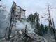 Prédio parcialmente destruído em Kiev após ataque aéreo russo, com fumaça subindo dos escombros e árvores danificadas ao redor.