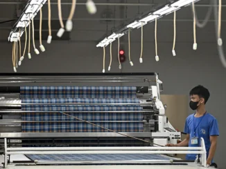 Trabalhador opera máquina automática de corte de tecido em fábrica de roupas na província de Thai Nguyen, Vietnã, em 2 de julho de 2025.
