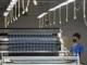 Trabalhador opera máquina automática de corte de tecido em fábrica de roupas na província de Thai Nguyen, Vietnã, em 2 de julho de 2025.