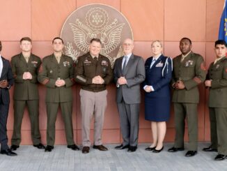 Militares e representantes civis do AFRICOM posam para foto oficial em frente a símbolo dos EUA, com bandeiras dos Estados Unidos e Namíbia ao fundo.