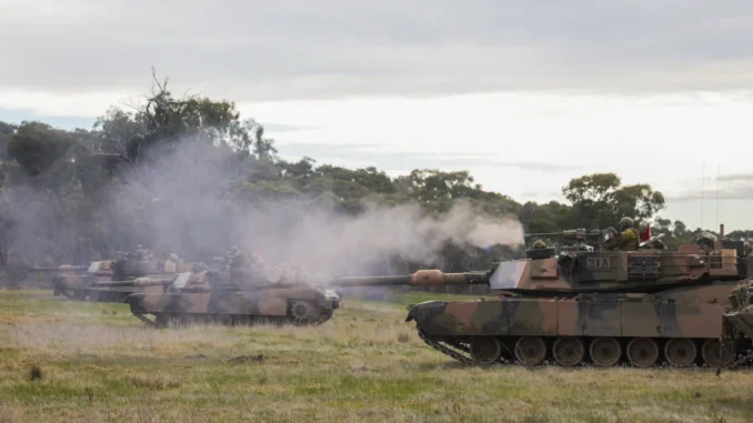 download Soldado do Exército Australiano dispara metralhadora pesada .50 a partir de um tanque M1A1 Abrams durante exercício militar em Victoria, Austrália.