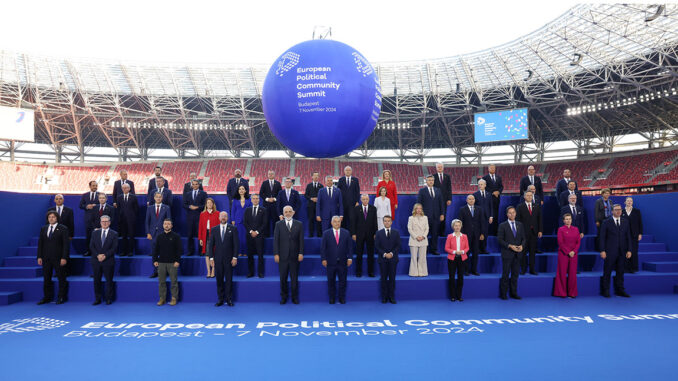 family_photo_epc_hu Foto oficial da cúpula da Comunidade Política Europeia em Budapeste, 7 de novembro de 2024, com líderes europeus reunidos em um estádio.