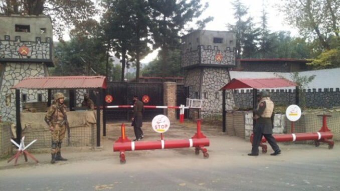 A fotografia captura um ponto de controle da Federal Constabulary no distrito de Swat, uma área com histórico de conflitos internos. Posto de controle da Federal Constabulary no Paquistão com soldados e barreiras de segurança em frente a portões fortificados.