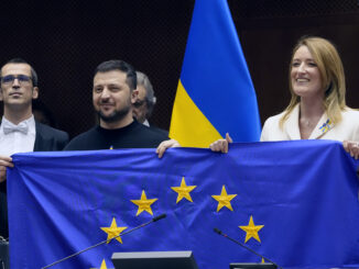 Presidente ucraniano Volodymyr Zelensky e líderes da União Europeia seguram a bandeira da UE durante visita ao Parlamento Europeu.