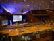 Auditório da Conferência Nacional do Espaço 2023 em Pretória, África do Sul, mostrando palco, telões e assentos do público.