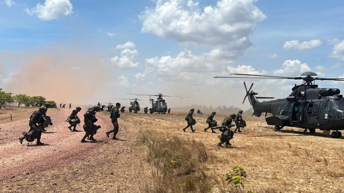 Militares desembarcando de helicópteros durante a Operação Atlas 2025 em região de campo aberto.