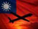 Silhueta de um drone militar voando ao pôr do sol, com a bandeira de Taiwan ao fundo.