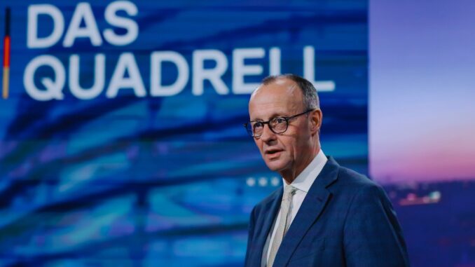 Friedrich Merz aborda burocracia e desafios econômicos em fevereiro de 2025 Friedrich Merz falando em um programa de televisão com fundo azul e o texto "Das Quadrell" ao fundo, usando terno azul e gravata clara.