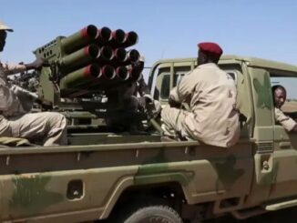 Soldados das Forças de Apoio Rápido (RSF) do Sudão em caminhonete militar equipada com lançadores múltiplos de foguetes no deserto de Darfur.