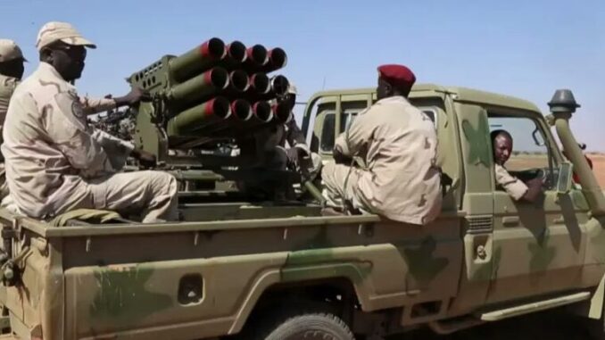 Soldados das Forças de Apoio Rápido (RSF) do Sudão em caminhonete militar equipada com lançadores múltiplos de foguetes no deserto de Darfur.