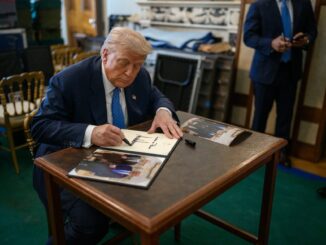 Donald Trump assinando documento oficial em ambiente formal, representando uma decisão presidencial importante.