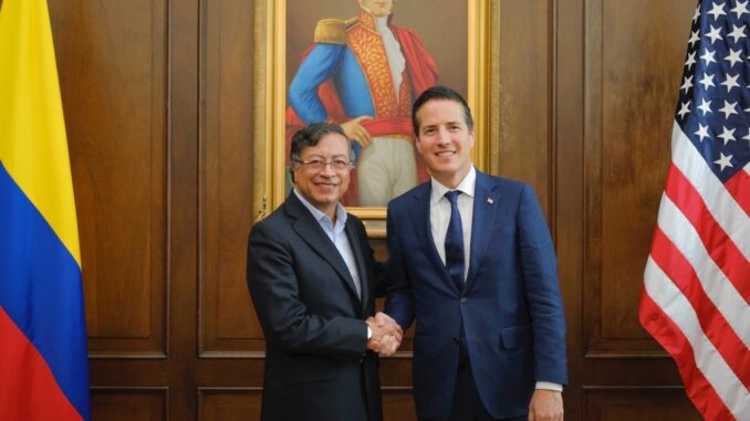 Petro Recebe Representante dos EUA em Bogotá Presidente colombiano Gustavo Petro cumprimenta representante dos EUA em encontro oficial em Bogotá, com bandeiras da Colômbia e dos EUA ao fundo.