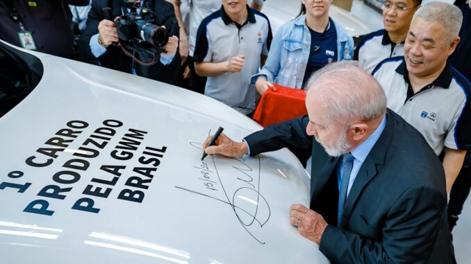 Presidente Luiz Inácio Lula da Silva assinando o primeiro carro produzido pela montadora chinesa GWM em Iracemápolis, cercado por equipe da fábrica.