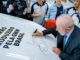 Presidente Luiz Inácio Lula da Silva assinando o primeiro carro produzido pela montadora chinesa GWM em Iracemápolis, cercado por equipe da fábrica.