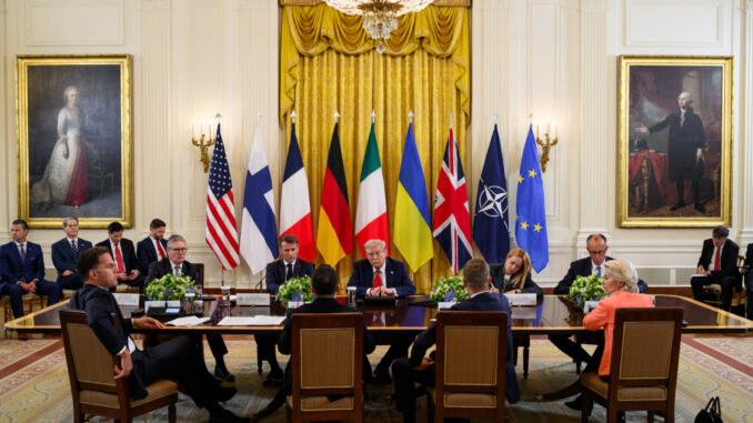 Líderes internacionais, incluindo Donald Trump e Volodymyr Zelensky, em reunião na Sala Leste da Casa Branca com bandeiras de EUA, Ucrânia, Alemanha, França, Finlândia, Itália, Reino Unido, OTAN e União Europeia ao fundo.