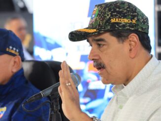 Nicolás Maduro usando boné militar enquanto fala ao microfone, acompanhado de outro oficial, em evento de mobilização de milícias na Venezuela.