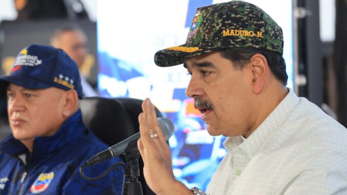 Maduro mobiliza milícias em resposta a ameaças externas Nicolás Maduro usando boné militar enquanto fala ao microfone, acompanhado de outro oficial, em evento de mobilização de milícias na Venezuela.
