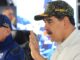 Nicolás Maduro usando boné militar enquanto fala ao microfone, acompanhado de outro oficial, em evento de mobilização de milícias na Venezuela.