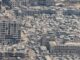 Vista aérea da cidade de Gaza mostrando prédios destruídos e ruas lotadas de destroços após ataques recentes.